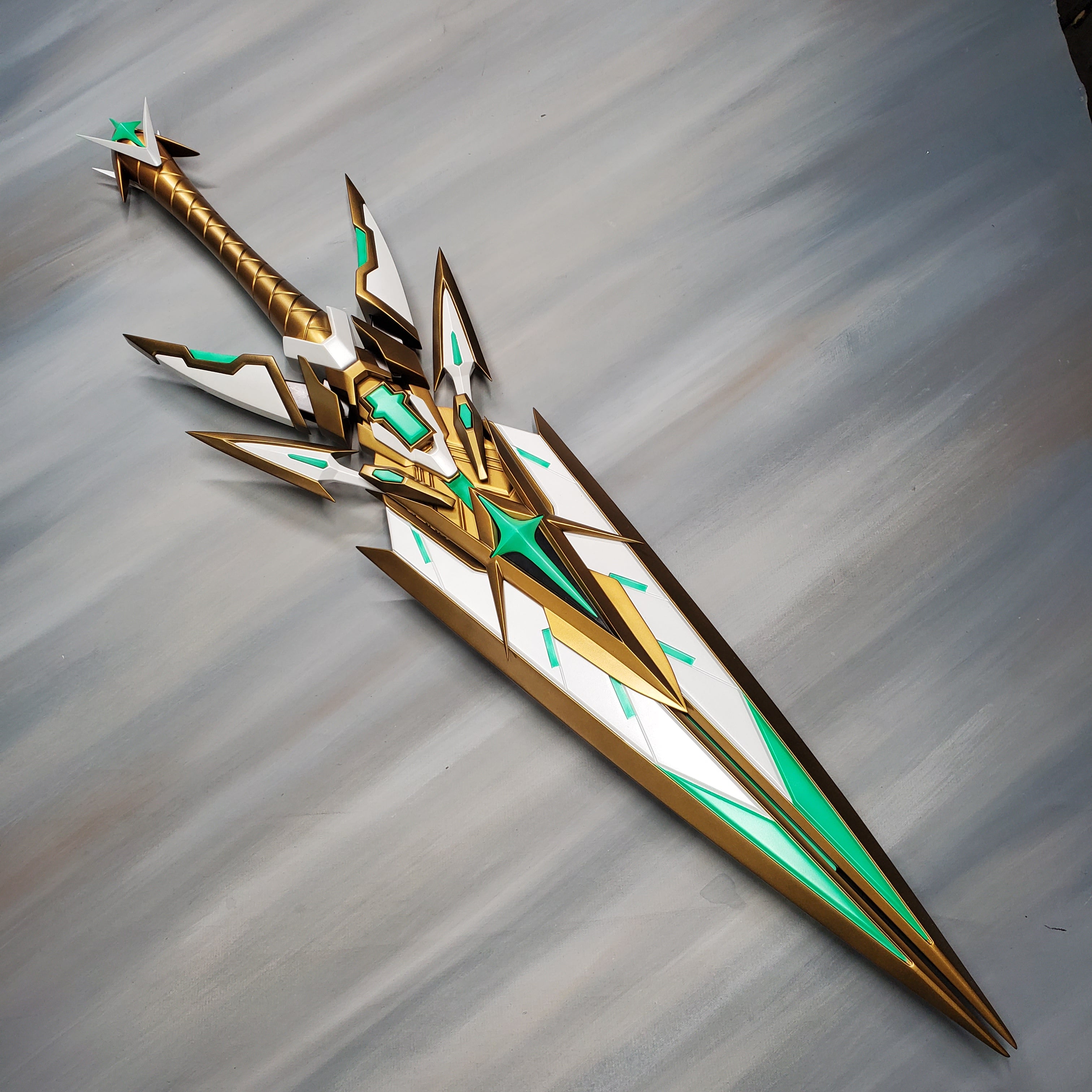 Decorative spear with gold and green accents on a gray background