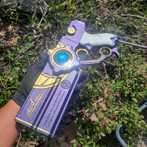 Purple and yellow toy gun with blue light held in front of green foliage