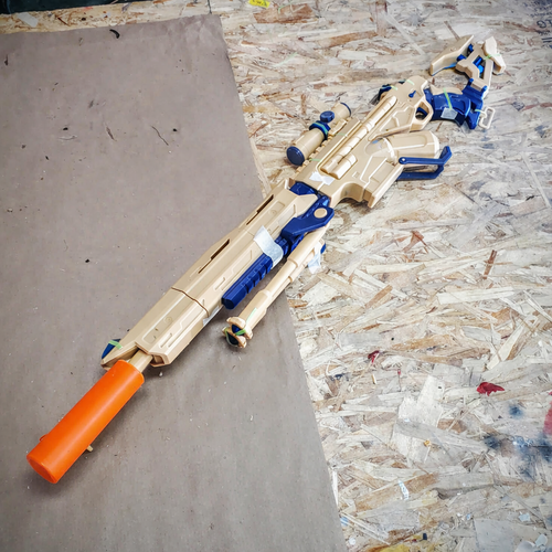 Toy gun with orange and blue design on a wooden surface